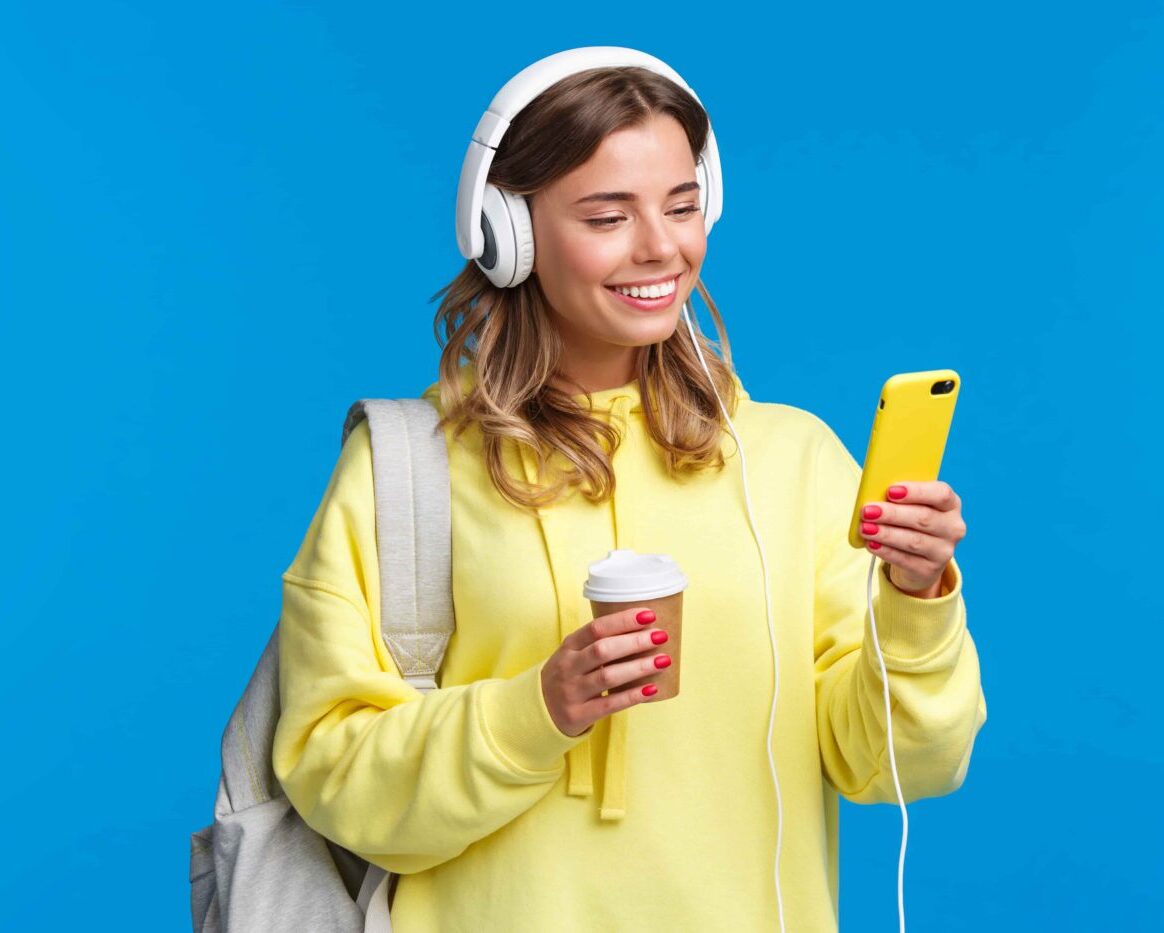 Mujer joven con audifonos viendo su teléfono